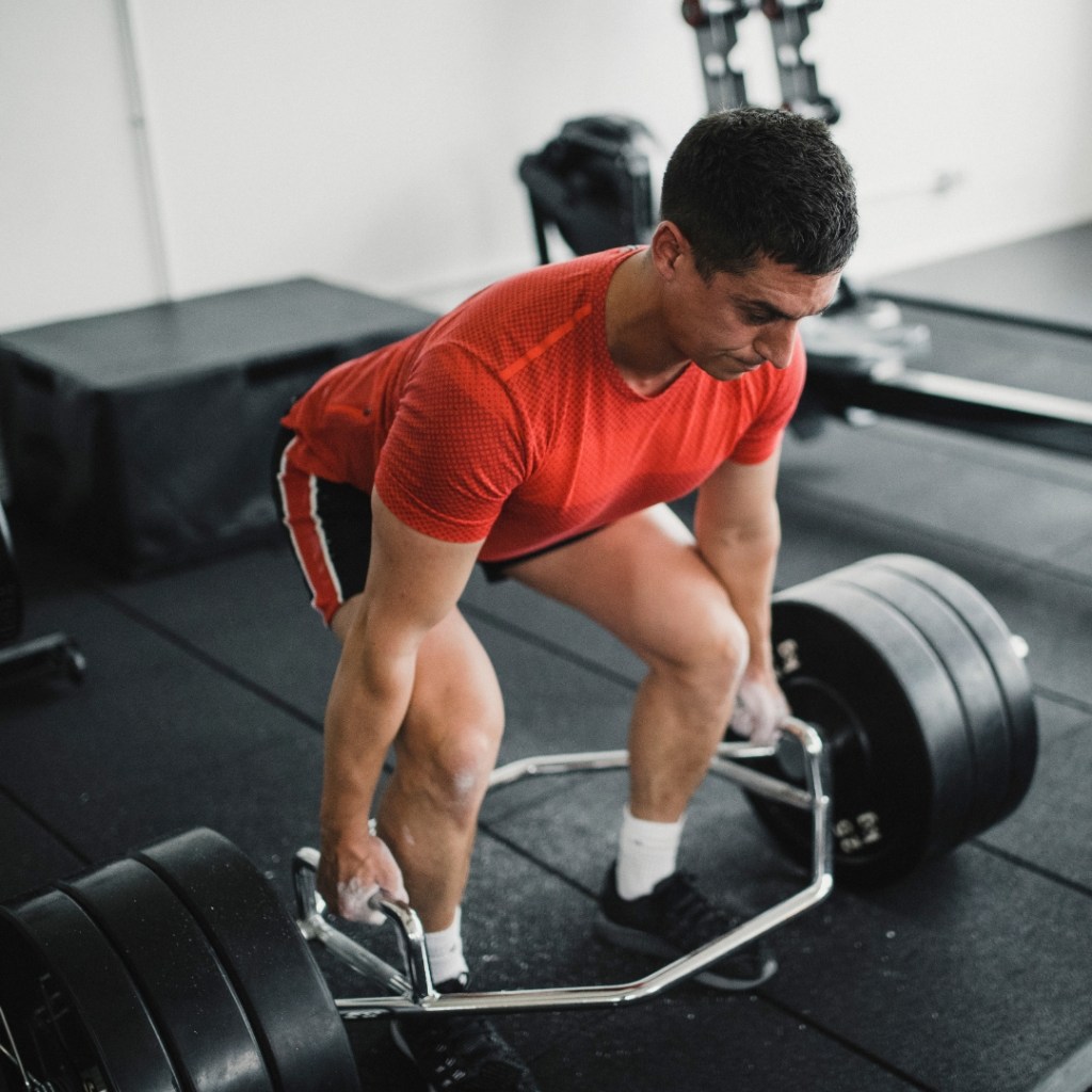 man doing a trap bar deadlift in the gym